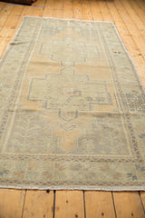 Vintage distressed Oushak rug runner with geometric pattern, textured pile in sand and pale seafoam.