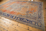 Vintage Oushak carpet corner detail, faded brick red distressed field, navy border, scrolling vinery.