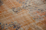 Distressed texture of vintage Oushak carpet with faded terra cotta, navy vinery, and abrashes.