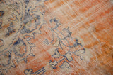 Distressed Oushak carpet pile showing faded brick red, navy, and ivory Rococo vinery.