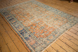 Distressed apricot and royal blue vintage Oushak carpet corner, revealing faded floral palmettes.