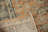 Distressed apricot Oushak rug pile with blue floral vines and hand-knotted reverse.