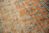 Worn apricot and ivory knot heads with dusty teal floral motifs on a distressed Oushak.