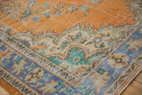 Distressed Oushak rug corner, faded tangerine and royal blue floral vinery with visible wear.