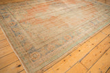 Distressed texture of vintage Oushak rug, showing faded apricot, mint, and ivory hues.