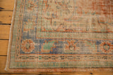 Vintage Oushak rug corner with distressed pile, showing apricot, mint, and blue border tones.