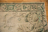 Corner of vintage distressed Oushak rug with pale green Arts & Crafts floral design.