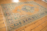 Worn pile and visible foundation on the distressed apricot field of a vintage Oushak rug.