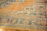 Close-up of the distressed border on a vintage Oushak carpet, with apricot, ivory, mint, and teal tones.