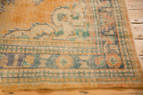 Hand-knotted vintage Oushak rug corner showing distressed apricot field and multi-color border.
