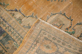 Close-up of distressed Oushak carpet pile, showing apricot, ivory, mint green, and teal.