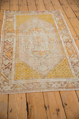 Distressed Oushak rug's bottom fringe and worn saffron yellow corner spandrel with foundation showing through.