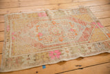 Distressed vintage Oushak rug corner, showing secured edge with even wear and bubble gum pink.