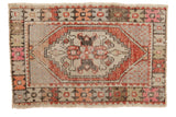 Distressed Vintage Oushak rug with geometric diamond medallion in terra cotta, pink, and beige.