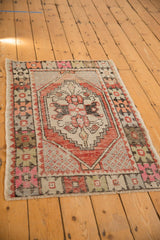 Textured detail of distressed Oushak rug's stepped medallion, seeds, blush pink, and terra cotta.