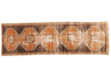 Distressed vintage Oushak runner with geometric medallions in rust terra cotta, charcoal, ivory.