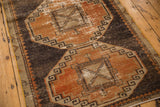 Distressed geometric medallion on vintage Oushak runner, with rust terra cotta and charcoal pile.
