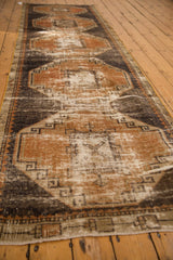 Distressed texture, geometric rust terra cotta and charcoal motifs on vintage Oushak runner.