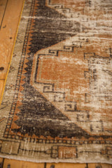 Distressed Oushak runner showing low pile, terra cotta, charcoal, and antique ivory geometric motifs.