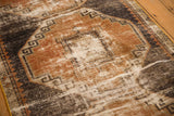 Distressed texture of vintage Oushak runner, revealing worn rust, charcoal, and ivory geometric motifs.
