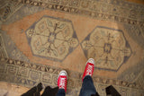 Distressed Oushak runner's pale sand apricot field, geometric medallion, delicate vinery.