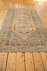 Distressed fringe and secured end of the vintage Oushak runner with faded geometric border.