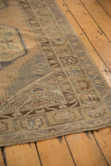 Distressed vintage Oushak rug border with geometric patterns, pale sand, and sea foam tones.