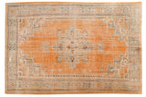 Distressed vintage Turkish Oushak rug with orange field, celadon green medallion, and faded floral design.
