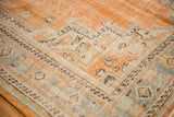 Distressed Oushak carpet, showing faded orange, ivory, celadon green geometric and floral motifs.