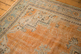 Distressed orange field and celadon border of vintage Oushak rug showing faint foundation.
