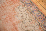 Distressed Oushak carpet border in faded orange, pale blue, and ivory.