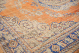 Burnt orange field of vintage Oushak rug, ivory border with royal blue serrated contours.