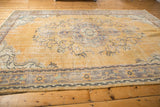 Etched texture and curvilinear floral vines on a pale gold vintage Oushak rug.