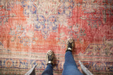 Vintage distressed Oushak carpet with worn cherry red and dusty navy floral etching.