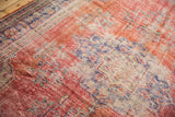 Worn pile and etched foundation on a vintage distressed Oushak rug with red, blue, and ivory florals.