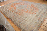 Distressed Oushak rug pile with rich faded orange and subtle blue patterns.