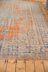 Hand knotted vintage Oushak carpet fringe and distressed pile in orange and blue tones.