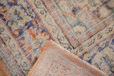 Distressed Oushak rug pile and reverse showing faded orange, blue patterns.