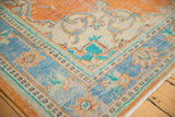 Close-up of vintage Oushak rug corner with distressed tangerine, sky blue floral vinery.