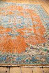 Distressed Oushak rug fringe and border, showing tangerine and sky blue texture.