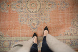 Distressed Oushak rug, pale royal blue trefoil patterns, and worn dusty peach pile.