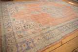 Distressed dusty peach field and pale royal blue, ivory scalloped border of vintage Oushak rug.