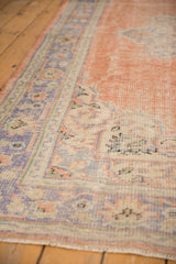 Distressed Oushak rug texture with dusty peach field and traditional pale royal blue border.