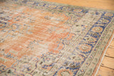 Distressed apricot field with floral vinery and navy border, showing etching to foundation.