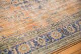 Worn texture and etched foundation on an apricot, navy, and sage green Oushak rug.