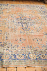 Decorative distressed texture of vintage Oushak carpet in apricot and navy blue tones.