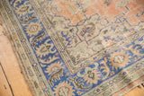 Vintage Oushak rug detail showing distressed pile, navy border, and apricot field with vinery.
