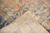 Distressed Oushak carpet fold displaying worn apricot pile and visible etched foundation.