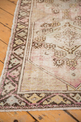 Distressed vintage Oushak runner's faded geometric border and etched field.