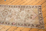 Textured end of vintage Oushak runner, with blush, silver, and brown geometric motifs.